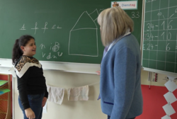 Kind und Lernpatin vor einer Schultafel